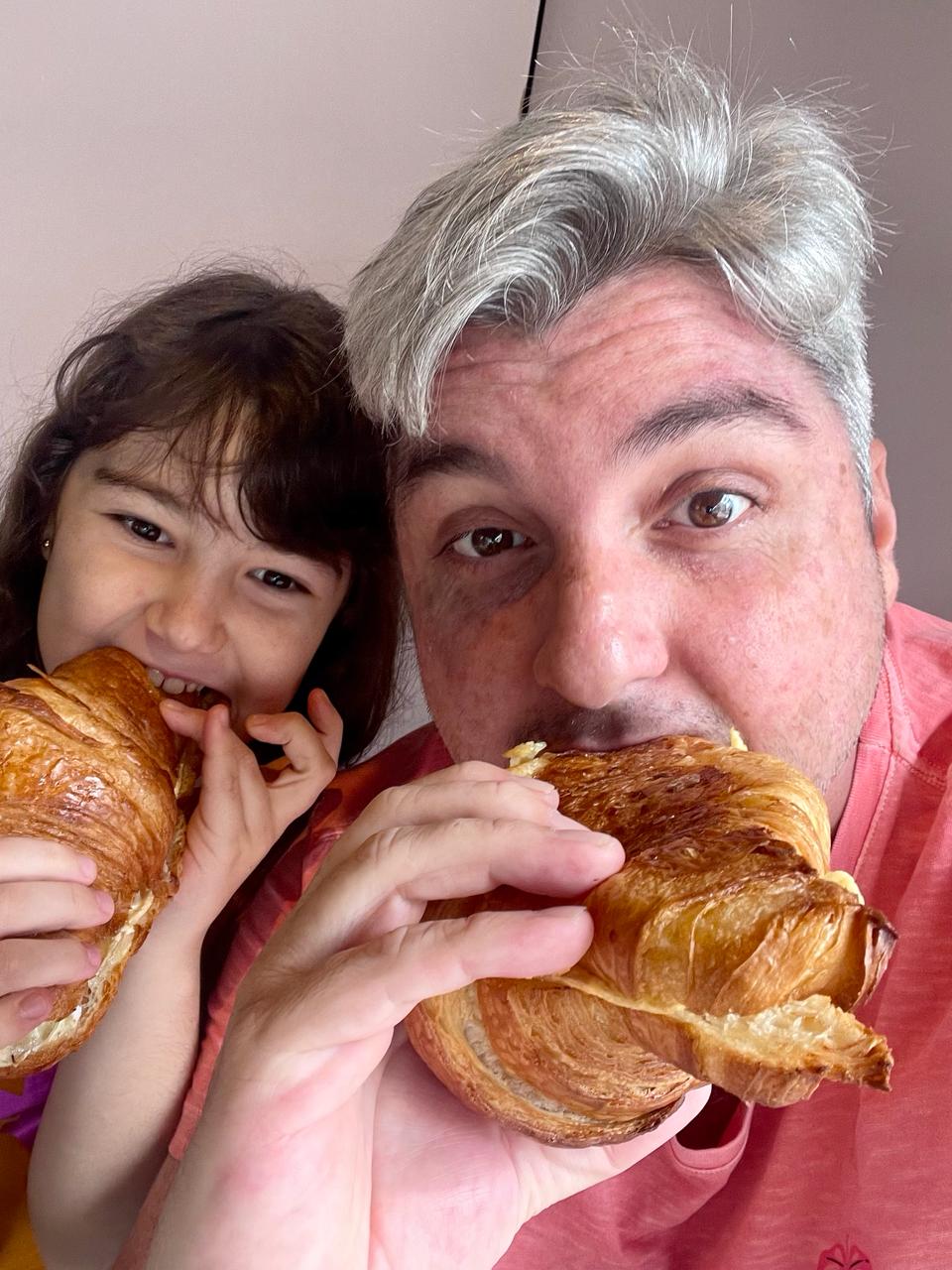 Serginho Jucá e Isys, sua filha, comendo croissant de brie com geleia de pimenta, na Ruca Confeitaria. 